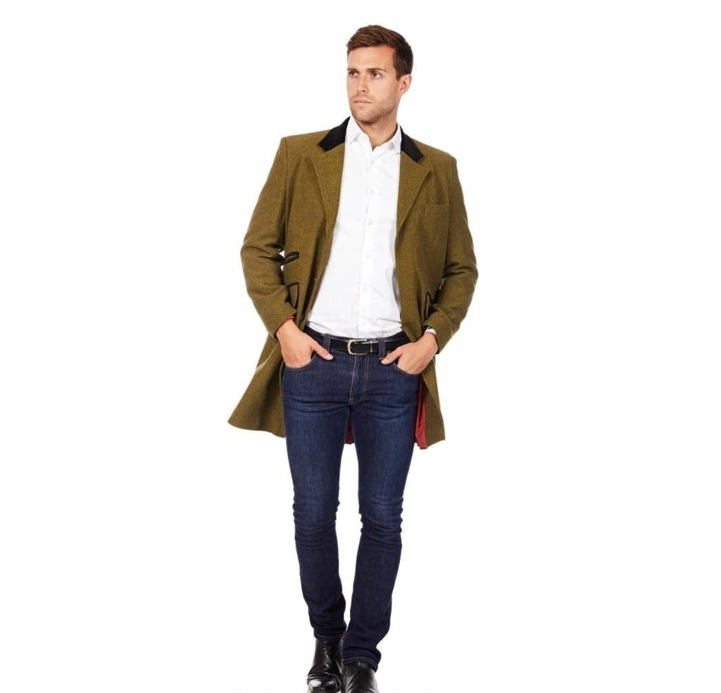 Man wearing a green coat, white shirt, and blue jeans on a white background with 'De La Creme Fashions' branding.