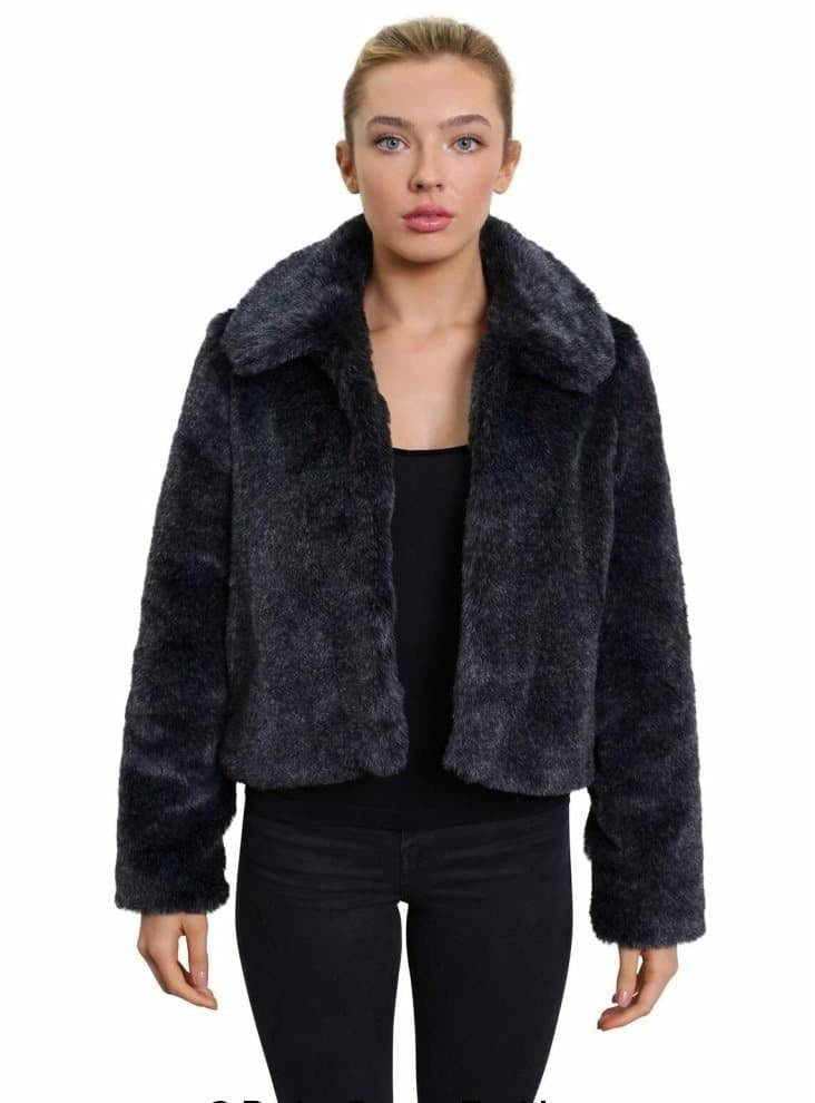 Woman wearing a dark gray faux fur jacket on a white background
